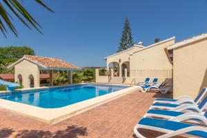 a villa with a swimming pool and chairs at Casa Henry in Jávea