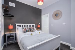 um quarto com uma cama branca e uma parede cinzenta em Delven House, Apartment 3 em Castle Donington