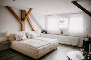 Un dormitorio con una gran cama blanca y una ventana en Altstadt-Residenz Manz, en Wachenheim an der Weinstrasse