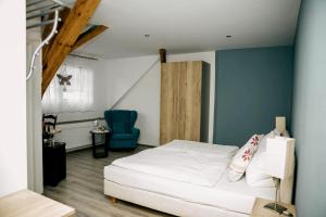 ein Schlafzimmer mit einem weißen Bett und einer blauen Wand in der Unterkunft Altstadt-Residenz Manz in Wachenheim an der Weinstraße