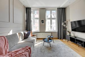 a living room with a couch and a tv at Downtown Apartments Old Town Ogarna IV in Gdańsk