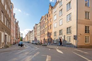 a city street with buildings and cars parked on the street at Downtown Apartments Old Town Ogarna IV in Gdańsk