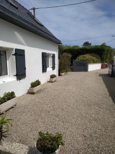 a house with a gravel driveway with potted plants at Ti Bihan - Meublé in Santec