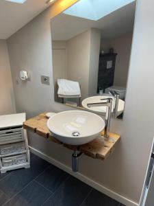 La salle de bains est pourvue d'un lavabo et d'un miroir. dans l'établissement Appartements Chez Maghy, à Aoste
