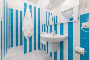 Łazienka z umywalką i niebiesko-białymi paskami. w obiekcie Blue Coral Suite B&B w Sorrento