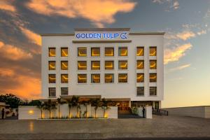 a white building with a sign on it at Golden Tulip Jalandhar in Jalandhar