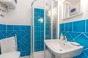 a blue tiled bathroom with a sink and a shower at Erica Piano Terra & Erica Primo Piano in Golfo Aranci