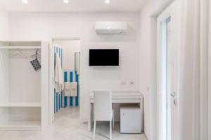 biały pokój ze stołem i telewizorem na ścianie w obiekcie Blue Coral Suite B&B w Sorrento +7 zdjęć