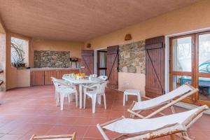 a room with a table and chairs on a patio at Erica Piano Terra & Erica Primo Piano in Golfo Aranci