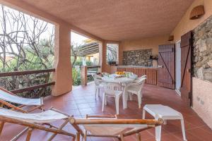 a dining room with a table and chairs on a balcony at Erica Piano Terra & Erica Primo Piano in Golfo Aranci +31 photos