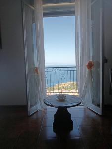 タオルミーナにあるJohnny and Mary's house breathtaking view locazioneturisticaのテーブル付きの客室で、海の景色を望めます。