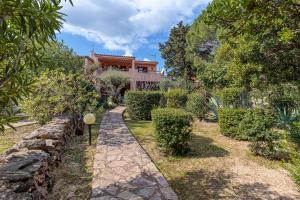 a garden with a stone path leading to a house at Erica Piano Terra & Erica Primo Piano in Golfo Aranci