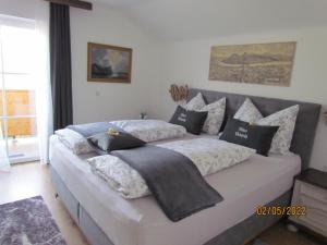 een slaapkamer met een groot bed met kussens erop bij Haus Victoria in Sankt Gilgen