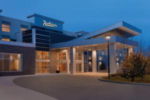 a building with a sign on the front of it at Radisson Hotel & Conference Centre Calgary Airport in Calgary