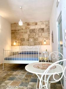 莫諾波利的住宿－Dimore Aria di Mare - Puglia Mia Apartments，一间卧室配有一张带桌椅的床