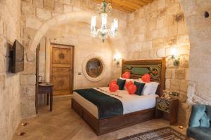 a bedroom with a king sized bed in a stone wall at Solo Cave Suites in Nevşehir +275 photos