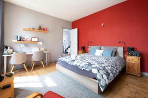 a bedroom with a bed and a red wall at Maison du jardin botanique 7 min centre et Gare Accueil Vélos in Tourcoing