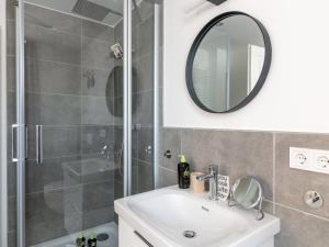 uma casa de banho com um chuveiro, um lavatório e um espelho. em limehome Bayreuth Spitalgasse em Bayreuth