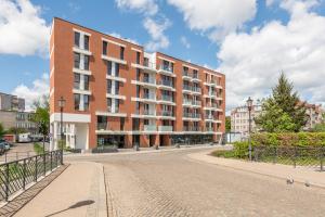 a large brick building on a street in a city at Downtown Apartments City Center Aura 40 in Gdańsk