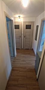 um corredor com duas portas e um piso de azulejo em M&M Suwałki Centrum em Suwałki