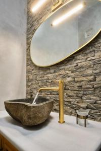 ein Badezimmer mit einem Steinwaschbecken und einem Spiegel in der Unterkunft Eressian Lodgings, Skala Eressos Beach in Skala Eresou