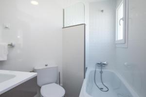 a bathroom with a toilet and a sink and a bath tub at Hotel Hipica Park in Platja  d'Aro