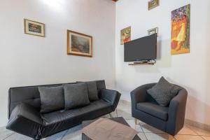 ein Wohnzimmer mit einem Sofa und einem TV in der Unterkunft Villa Lidia vicino al mare in Solanas