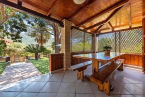 eine Außenterrasse mit einem Holztisch und einer Bank in der Unterkunft Villa Lidia vicino al mare in Solanas