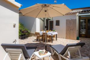 eine Terrasse mit Tisch und Sonnenschirm in der Unterkunft Casa Voramar Son Serra Beach in Son Serra de Marina