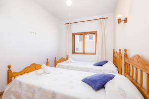 zwei Einzelbetten in einem Zimmer mit Fenster in der Unterkunft Casa Voramar Son Serra Beach in Son Serra de Marina