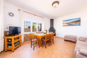 ein Wohnzimmer mit einem Esstisch und einem TV in der Unterkunft Casa Voramar Son Serra Beach in Son Serra de Marina