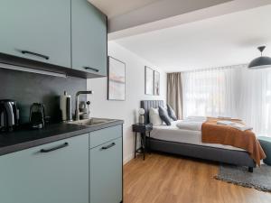 een keuken en een slaapkamer met een bed en een wastafel bij limehome Bayreuth Spitalgasse in Bayreuth