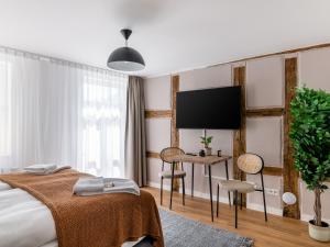 a hotel room with a bed and a flat screen tv at limehome Bayreuth Spitalgasse in Bayreuth