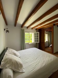 a bedroom with a large white bed with a window at Baketsua in Saint-Pée-sur-Nivelle