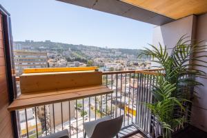 a balcony with chairs and a view of a city at PORT CITY HAIFA - Downtown Luxury Apartments - MAMAK in Haifa