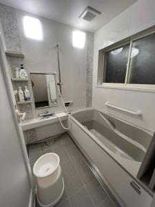 a bathroom with a tub and a toilet and a sink at Hakuba Mountain Chalet in Hakuba