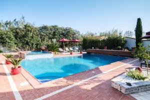 una piscina en un patio trasero con un patio de ladrillo en Gîtes La Catalane, en Théza