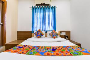 a bedroom with a bed with a colorful quilt on it at FabExpress Relax Inn in Sarkhej