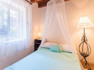 een hemelbed in een slaapkamer met een raam bij Summer House Silvija in Zaton