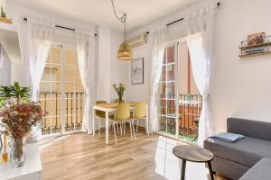 ein Wohnzimmer mit einem Tisch und gelben Stühlen in der Unterkunft Bright & Breezy MERCED in Málaga