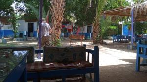 un hombre parado en un patio con una silla en Al Salam Camp, en Luxor