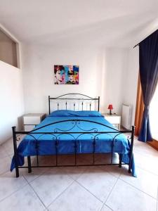 una camera bianca con letto blu di Il Faro a Porto Torres
