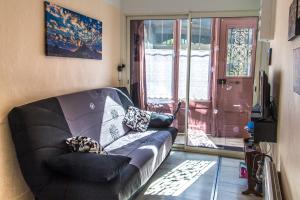 a living room with a leather couch and a sliding glass door at Gîte du rempart avec Balnéo, Garage, 2 SDB 2WC vue sur les monuments in Le Puy-en-Velay