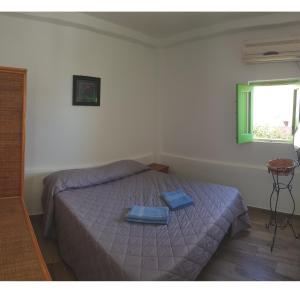ein Schlafzimmer mit einem Bett mit zwei blauen Handtüchern darauf in der Unterkunft Da Luciano in Stromboli