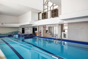 una grande piscina con acqua blu in un edificio di Water Front Luxury Family Apartment a Herzelia