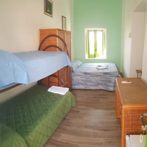 a small bedroom with two beds and a table at Da Luciano in Stromboli