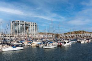 a group of boats docked in a harbor with a building at Water Front Luxury Family Apartment in Herzliya