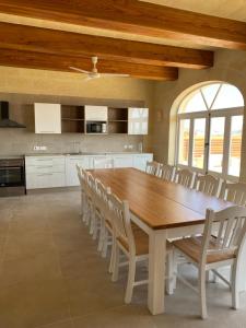 une grande cuisine avec une table et des chaises en bois dans l'établissement Ta' Giga Farmhouse, à Sannat