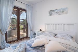 a bedroom with a large bed and a balcony at Zielone Miejsce in Karwia