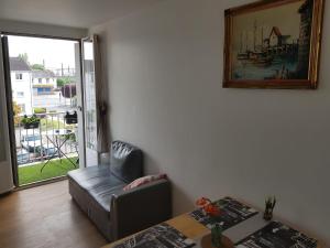 een woonkamer met een stoel en een foto aan de muur bij Superbe appartement de 41m2 en résidence privé in Fleury-les-Aubrais